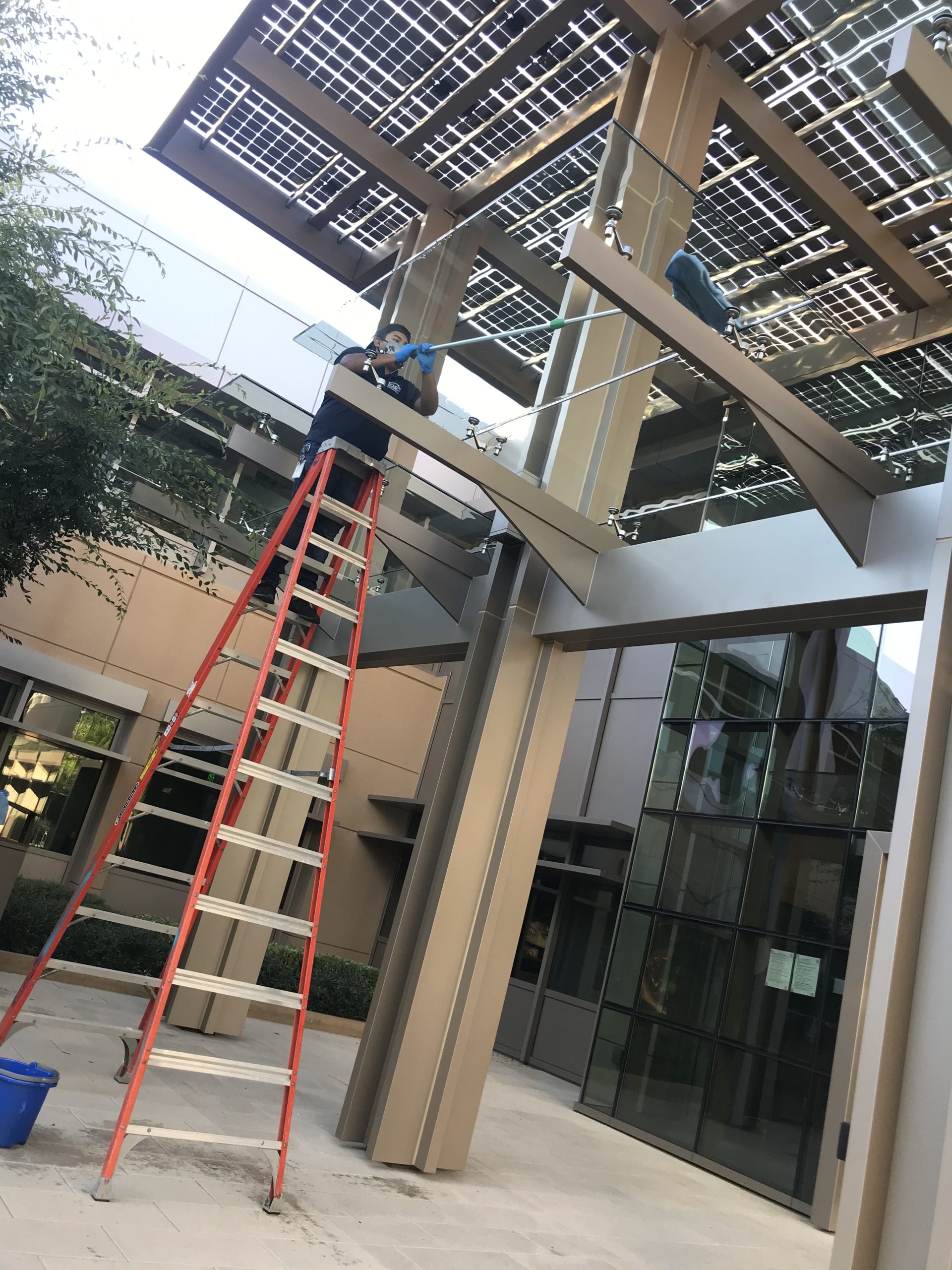 Woman cleaning elevated glass